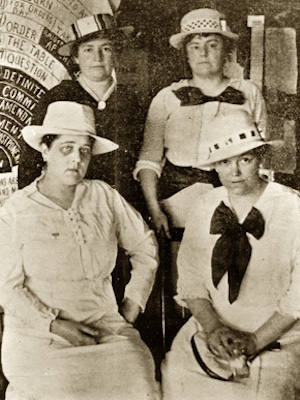 This group portrait photo shows four middle-aged women in long dresses and wide-brimmed hats. They sit in two rows of two. The two on the right have large, dark bows at their collars. The woman at the bottom left is Pattie Ruffner Jacobs.
Photographer unknown. Source: http://www.encyclopediaofalabama.org/article/m-2500. 26 Aug 1920. Public domain via Wikimedia Commons